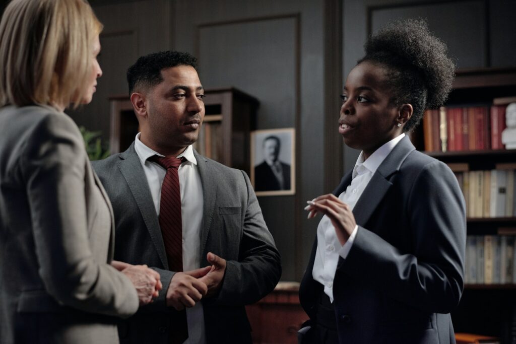 three diverse attorneys have a discussion in law office