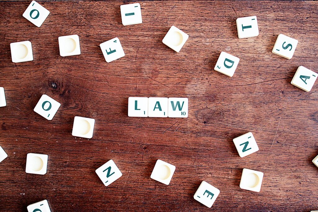 scrabble tiles on wood table spell out the word law