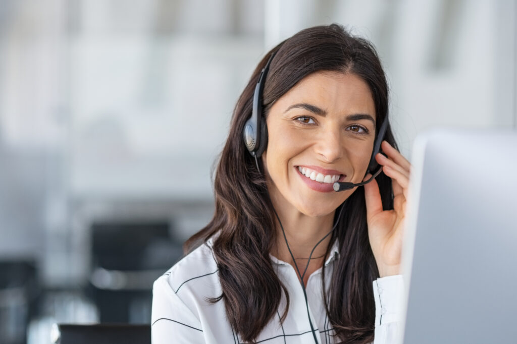 female client intake receptionist talks on headset while smiling at camera